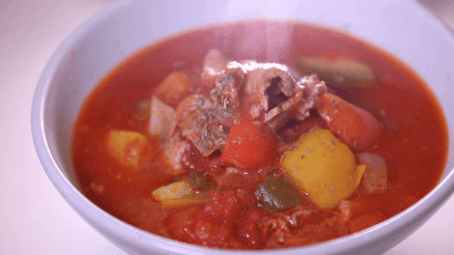 Bowl of steaming tomato stew with vegetables