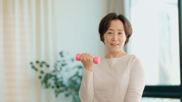 여성이 실내에서 덤벨 운동을 하는 모습