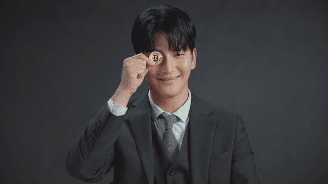 비트코인 동전을 들고 미소 짓는 남자