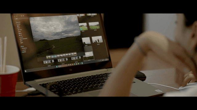 Back view of person looking at photo on laptop