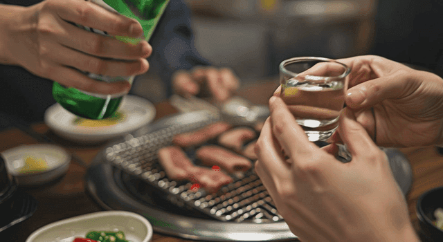 고깃집에서 소주잔에 소주를 따르는 장면