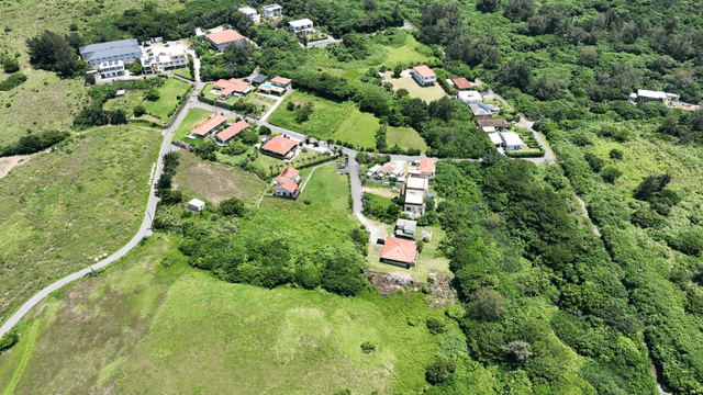 Aerial view of a rural village surrounded by lush greenery