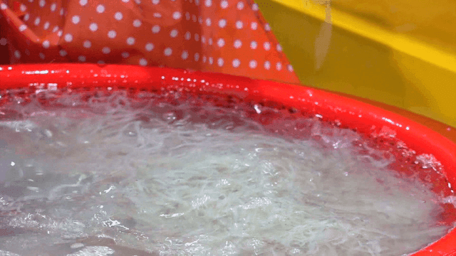 빨간 바구니에서 젓가락으로 실치를 손질하는 상인