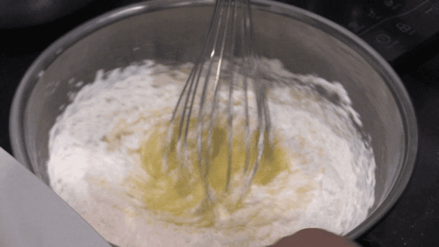 Whisk mixing baking ingredients in steel bowl
