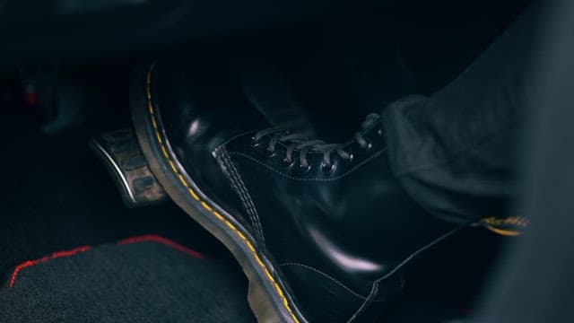 Close-up view of a foot pressing a car pedal