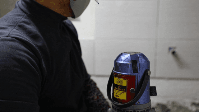 Worker using a laser level indoors