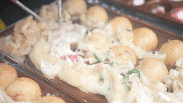 Cooking takoyaki on a hot griddle