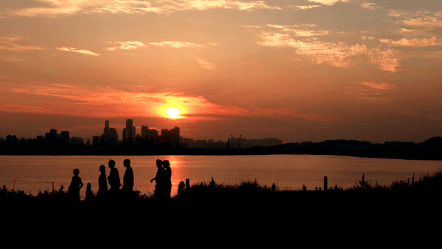 해질녘 강가를 걷는 사람들