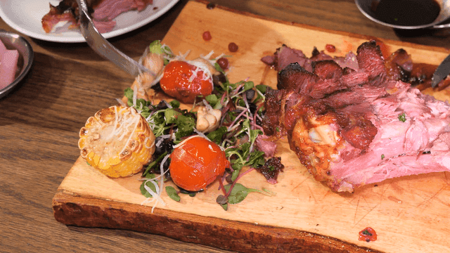 Roast turkey legs and salad on wooden cutting board