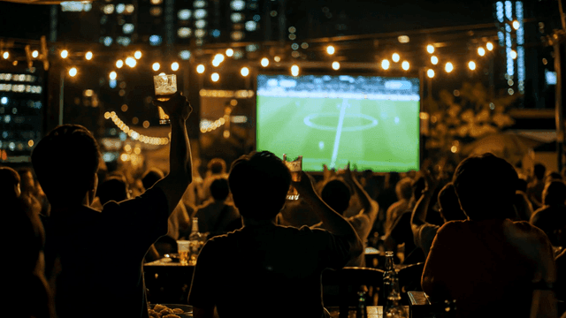 People cheering for soccer while drinking beer outdoors