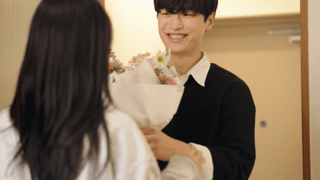 Wife greeting husband returning home with bouquet