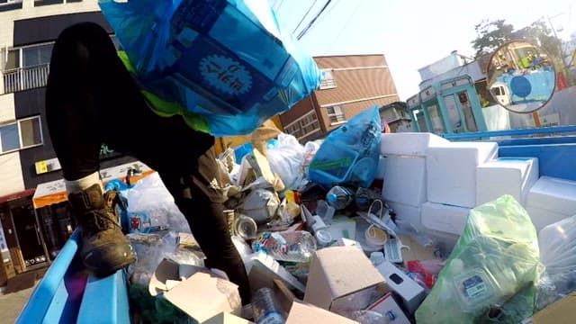 Worker sorting recycled waste on a truck