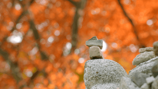 Stacked stones with autumn leaves in background