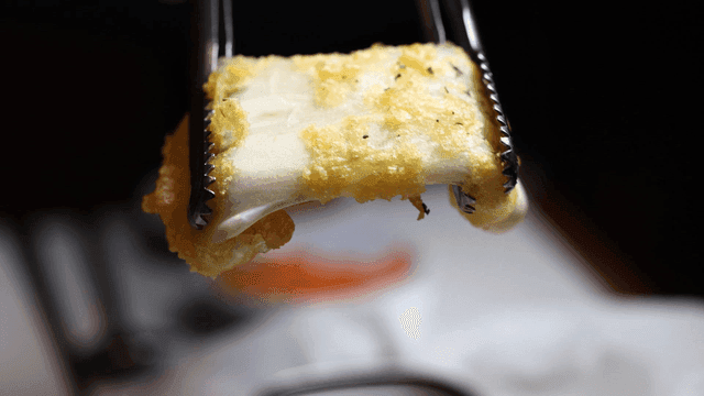 Stretchy fried cheese with tongs