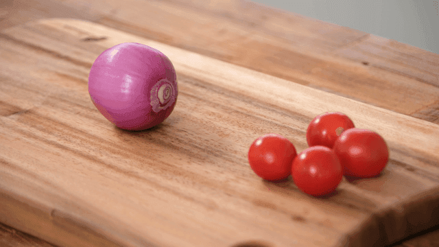 Red onion and cherry tomatoes on a board
