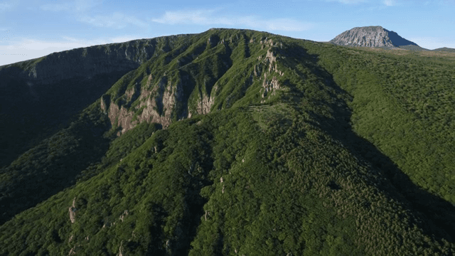 Green mountains under a clear sky