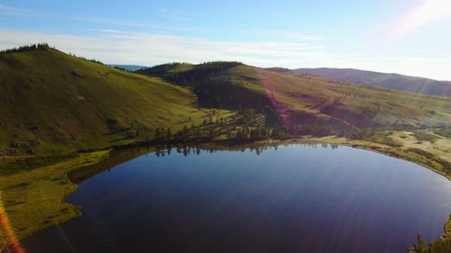 Tranquil lake surrounded by green hills