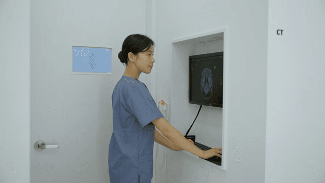 간호사가 CT 스캔 기계를 조작하는 모습