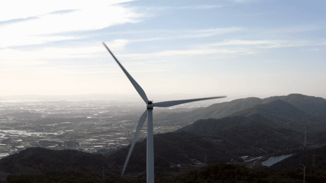 마을이 보이는 산악 지역의 풍력 터빈