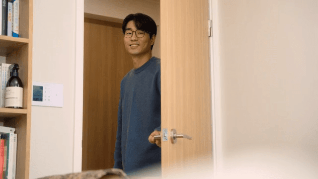 Man closing a door with a smile