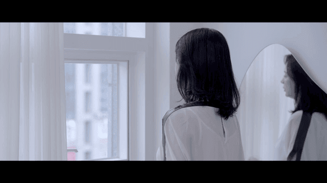 Woman hanging up phone at window