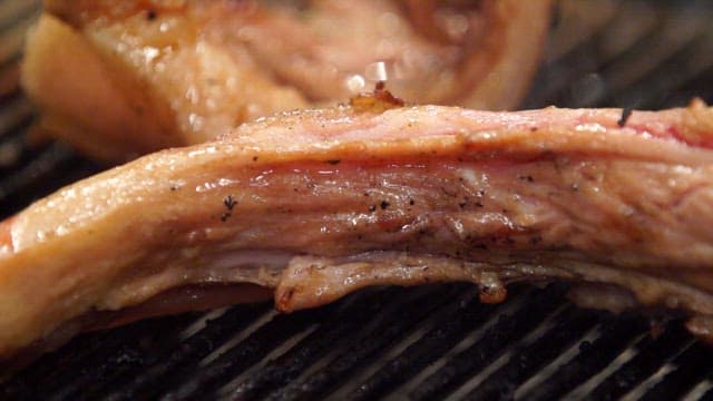 Grilled pig tail, golden brown on a grill at a meat restaurant