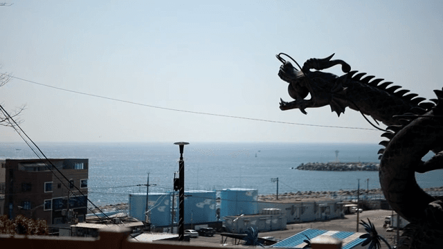 용 조각상이 있는 해안 풍경