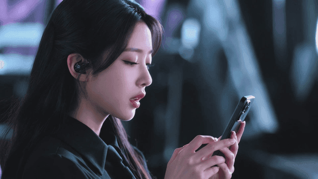 무선 이어폰을 귀에 끼고 스마트폰을 사용하는 여성