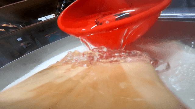 Pouring water into a pot in a kitchen