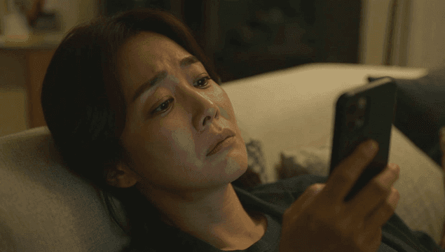 소파에 누워 스마트폰을 사용하는 여성