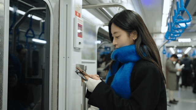 Profile of a woman using her cell phone on the subway