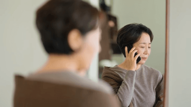 실내에서 전화 통화하는 여성