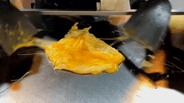 Egg omelette being cooked on a hot griddle