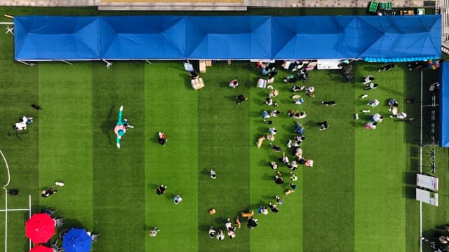 빨갛고 파란 파라솔이 있는 행사장에 모인 사람들