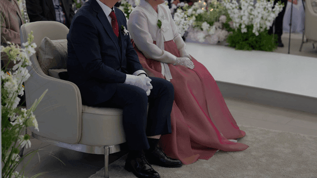 Bride and groom's parents sitting in wedding hall