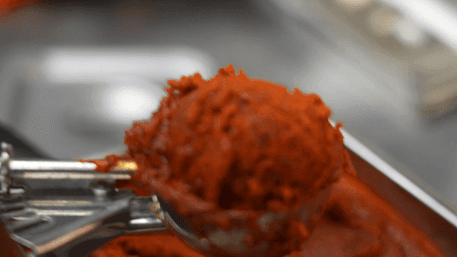Scooping out gochujang sauce in kitchen