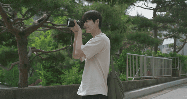 공원에서 사진을 찍는 젊은 남성