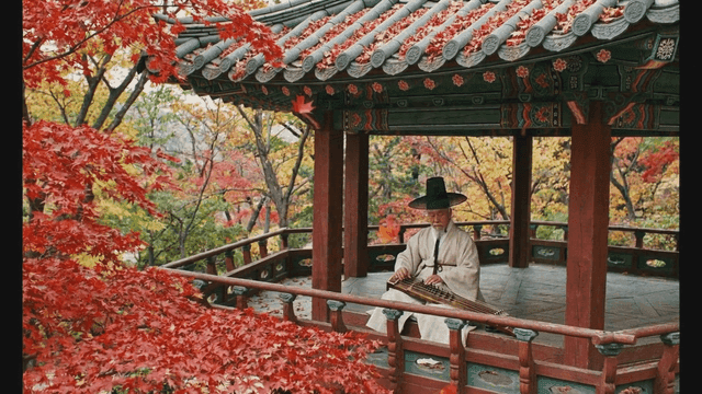 Man playing traditional geomungo in pavilion surrounded by autumn foliage