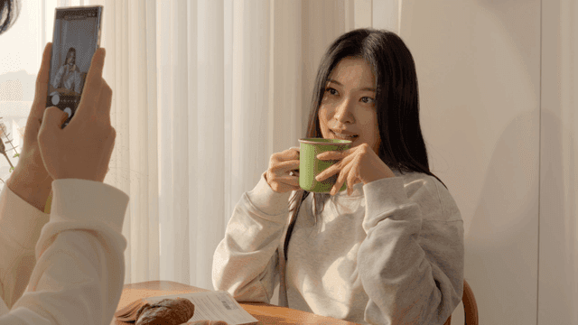 아침식사 식탁에서 스마트폰으로 사진을 찍는 커플