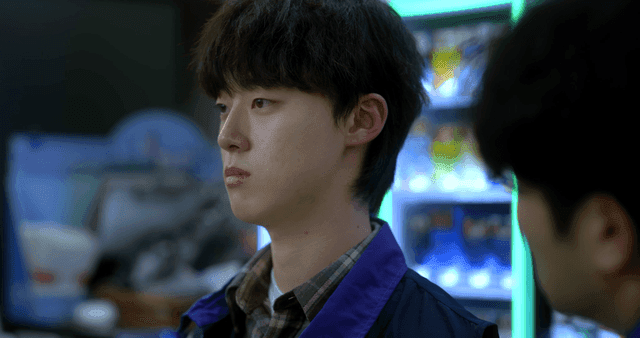 Back of man speaking to young man at convenience store