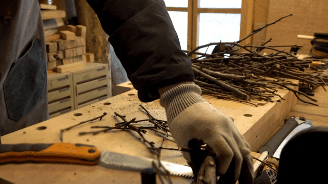 작업대에서 가지를 다듬는 공예가