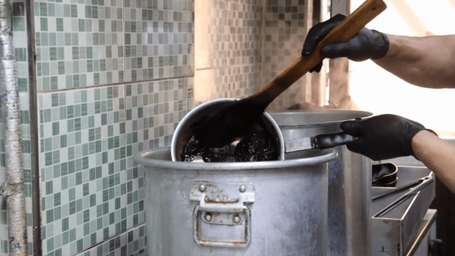 Scene of pouring sauce into a large pot