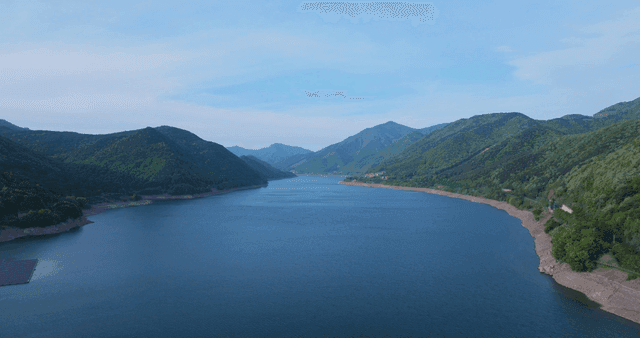 Tranquil lake flowing between green mountains