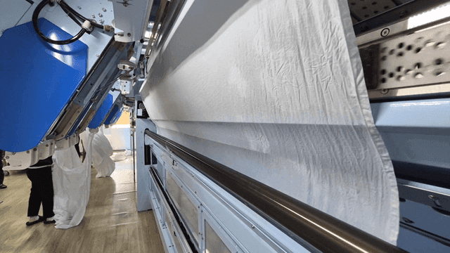 공장에서 가동 중인 대형 천 세탁 기계