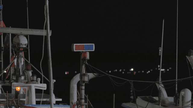 Ship with flashing lights at night.