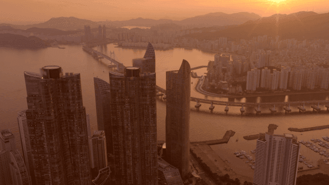 고층 건물이 있는 바닷가 도시의 일몰