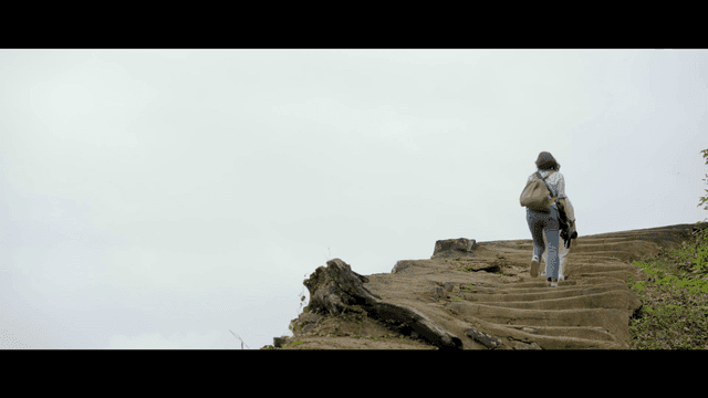 Two women hiking up a stone path