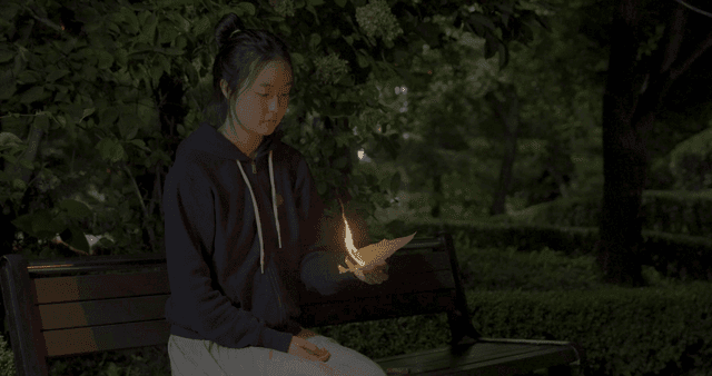 공원 벤치에서 불타는 편지를 내려놓는 소녀