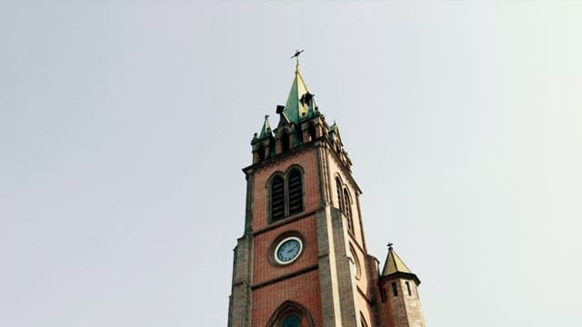 Old brick cathedral with a clock tower on a clear day