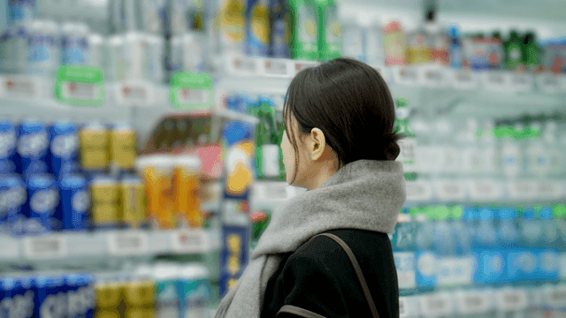 Woman choosing alcohol at supermarket